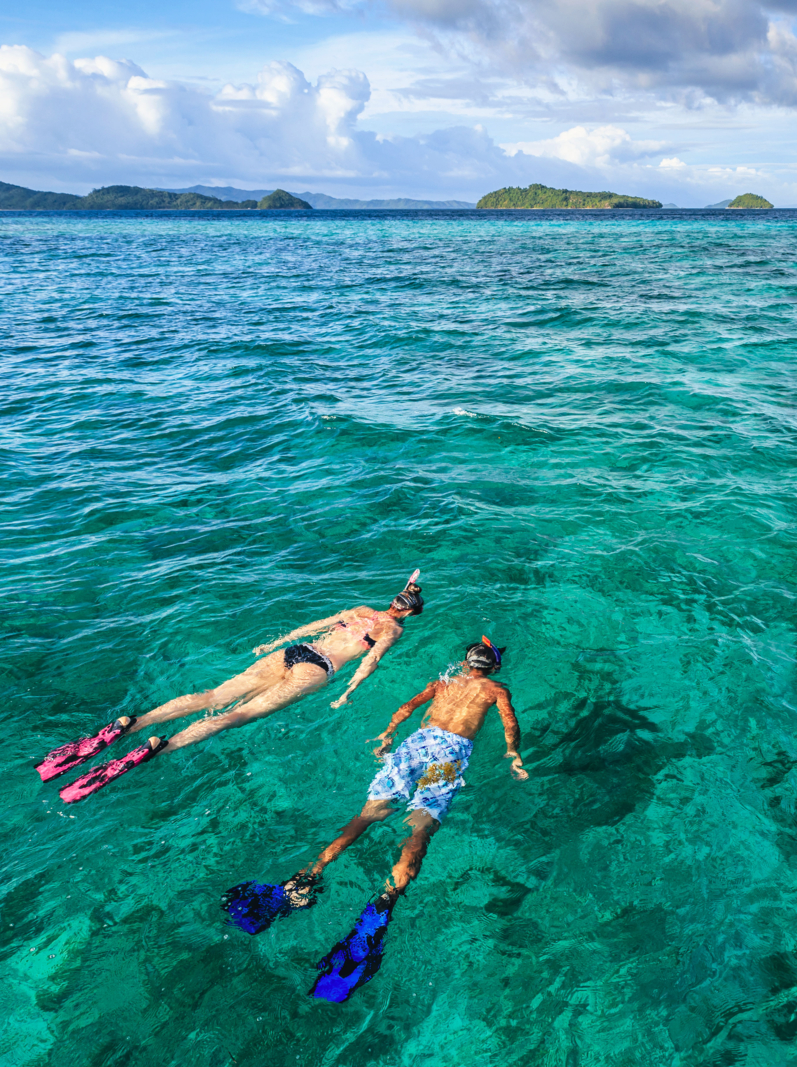 Young caucasian woman with her boyfriend snorkeling and watching turtles, East China Sea, Palawan Island, East China Sea, Philippines, Southeast Asia.