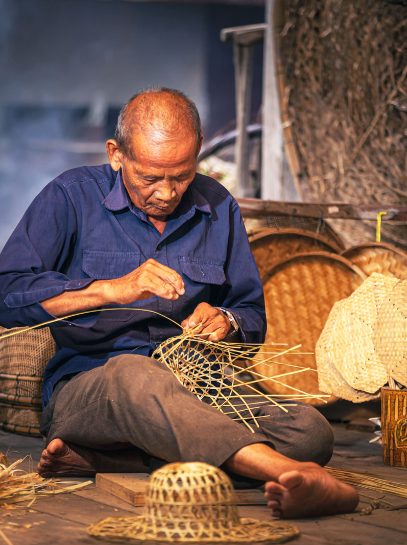 Craftsmen of Thai. An old man who is the craftsmanship in Buriram Province Weaving a basket of bamboo. Craftsmanship that has been carried on since ancient times