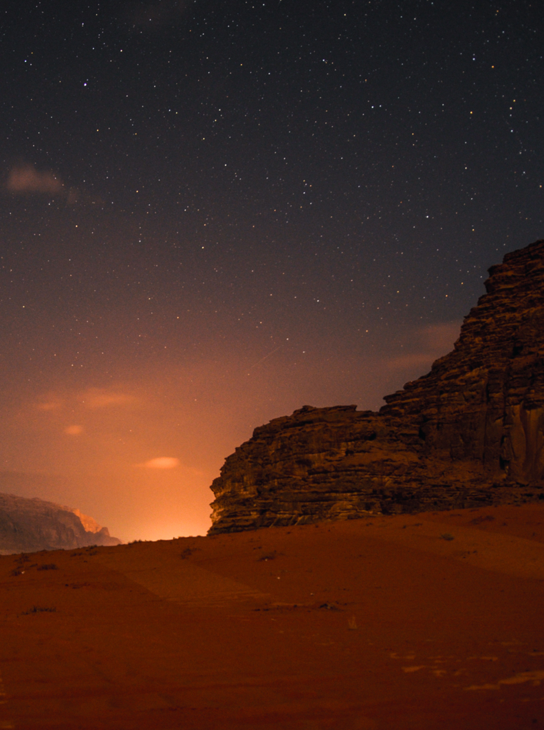 Ciel nocturne photo avec étoiles dans le désert du Wadi Rum en Jordanie avec panorama sur la montagne.