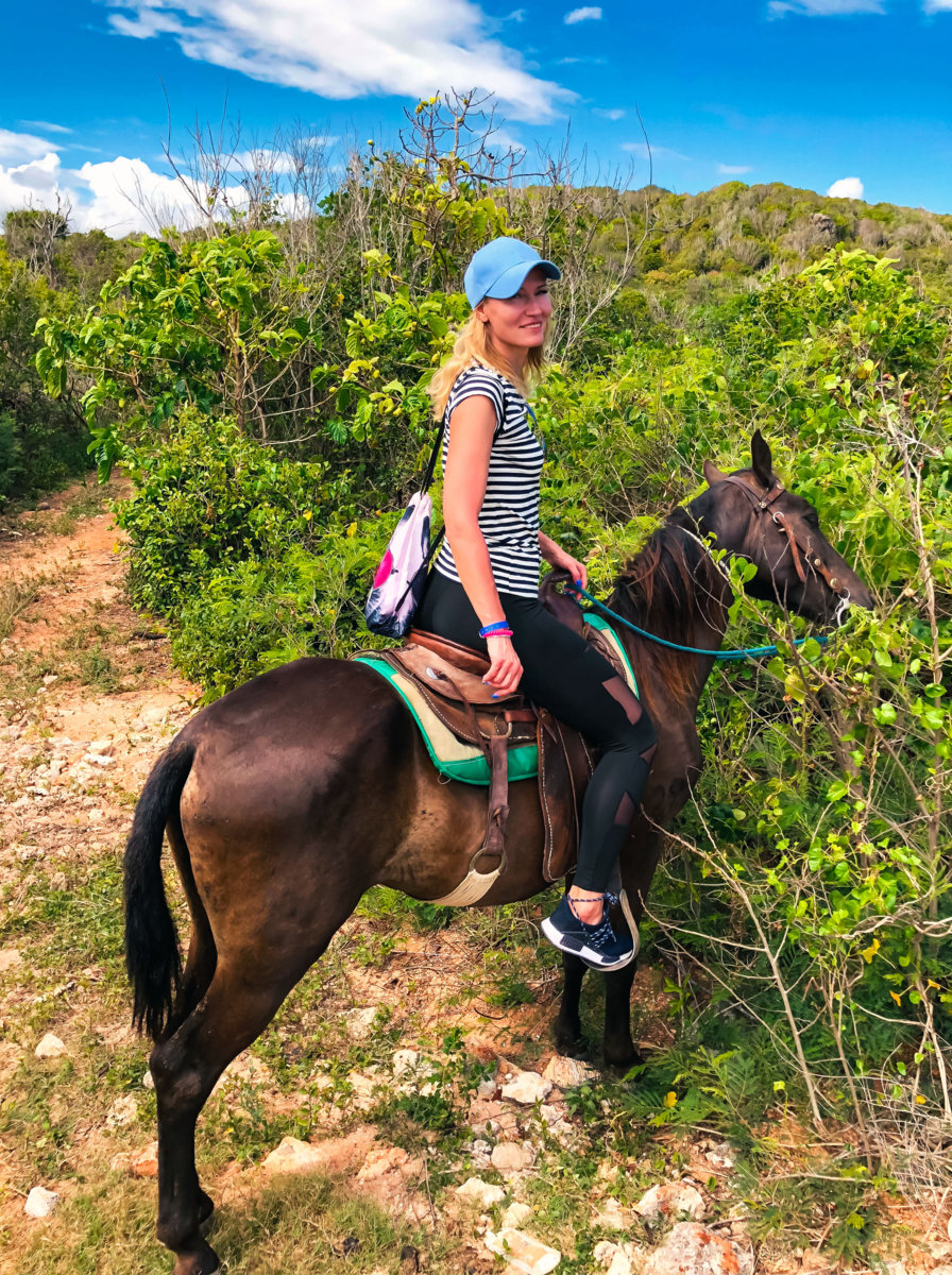 Horse riding tourists in Cuba. Girl on a horse on a beach.