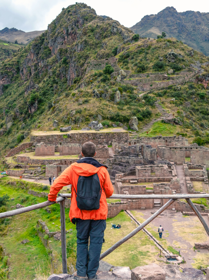 Jeune touriste masculin voyageant seul dans la vallée du Sacré. Randonneur solitaire avec sac à dos pour visiter les ruines d'inca, point de repère de la région de Cusco, Pérou, Amérique du Sud
